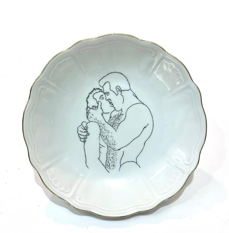 Omri Danino Porcelain Plate engraved with a drawing of older hairy man and younger man kissing, in black engraving on white plate with golden rim