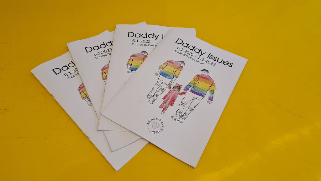 a few catalogs together from the exhibition "Daddy Issues" with an illustration of a gay couple wearing a pride flag top and holding a little girl